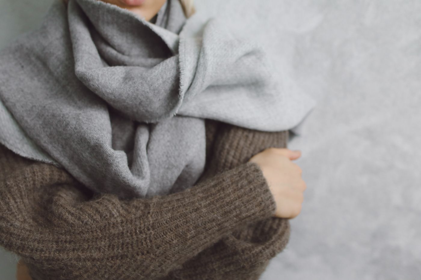 Monoloom Weft Scarf, a thick folded scarf held against a knit sleeve
